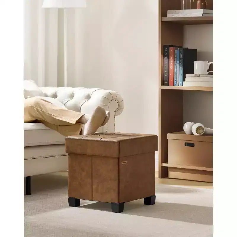 Pouf contenitore a cubo da 38x38x40 cm con gambe. Capacità 37 L. Poggiapiedi in pelle sintetica.