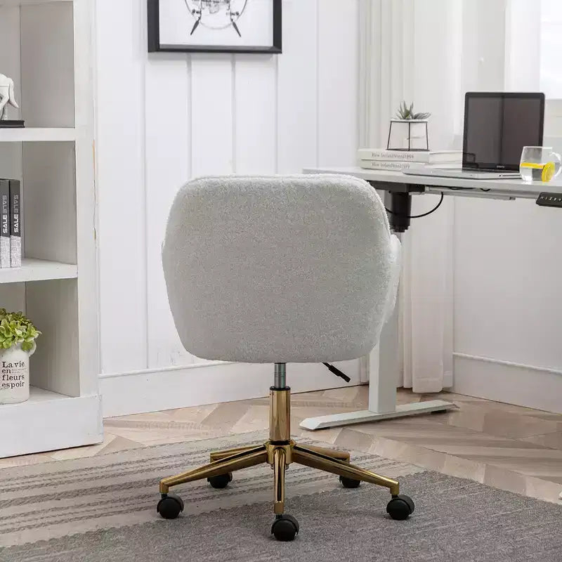 Questa sedia girevole da ufficio è regolabile in altezza, ha le ruote, le gambe placcate in oro e la base cromata.
