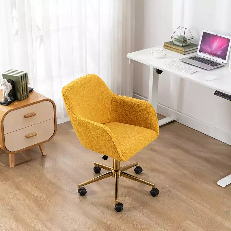 Questa sedia girevole da ufficio è regolabile in altezza, ha le ruote, le gambe placcate in oro e la base cromata.